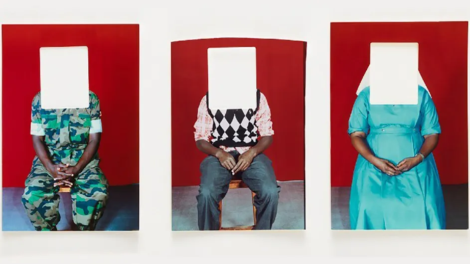 Three seated people with white rectangles blocking their faces.