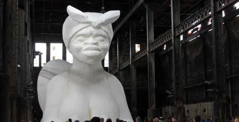 a white sculpture of a women wearing a head scarf tied to the top and front of head