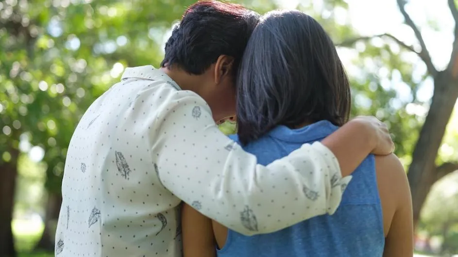 View from behind of two women embracing